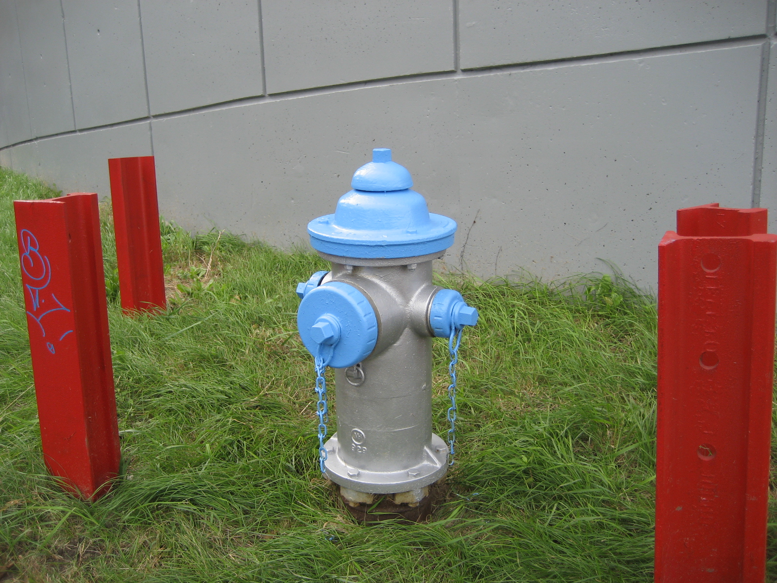 a fire hydrant is shown behind three red posts