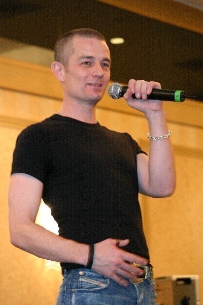 a male in a black shirt is holding a microphone