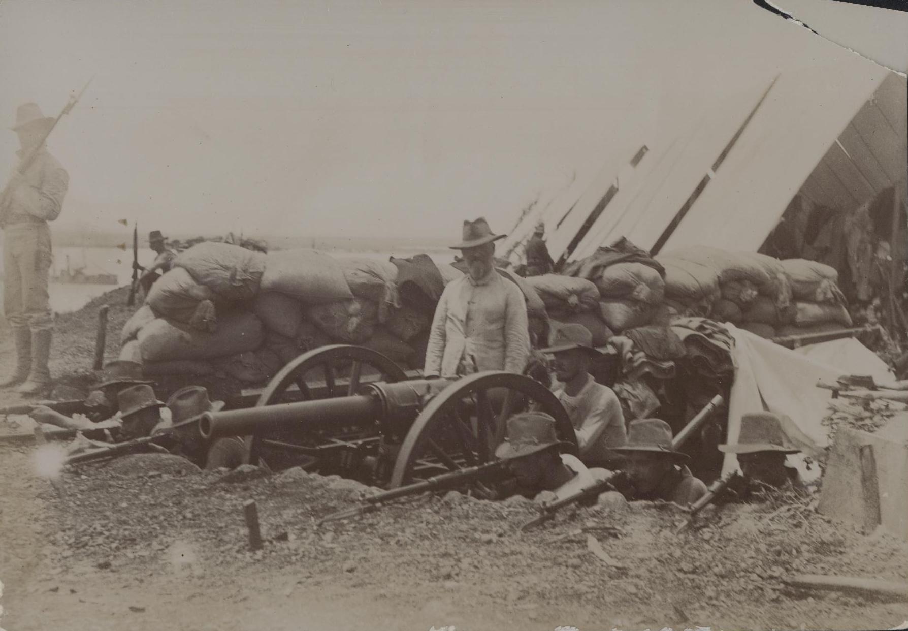 a man standing near many old military equipment