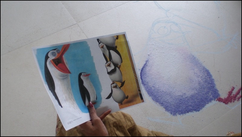 a person holding up an image of two penguins