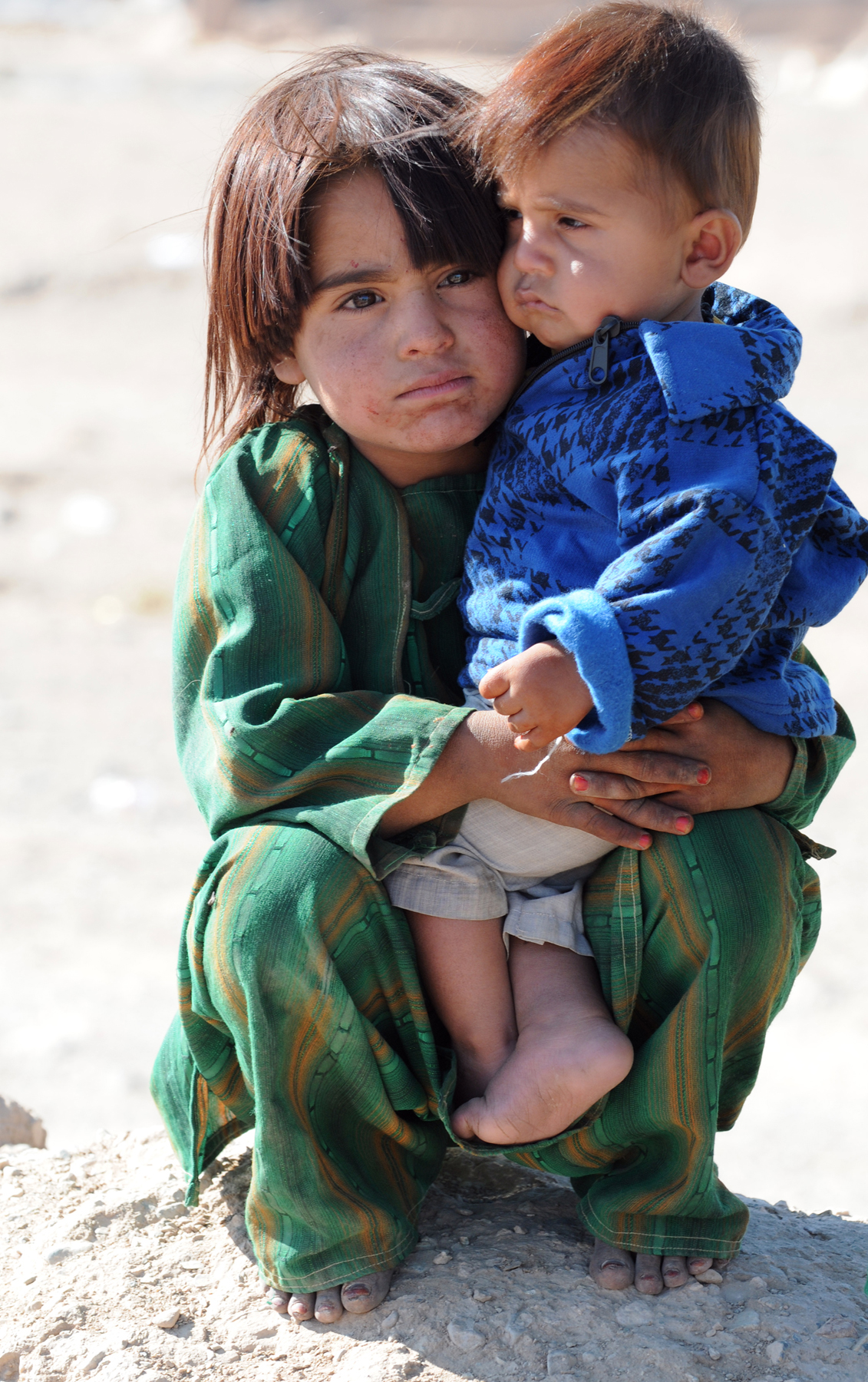 an image of two children sitting on the ground