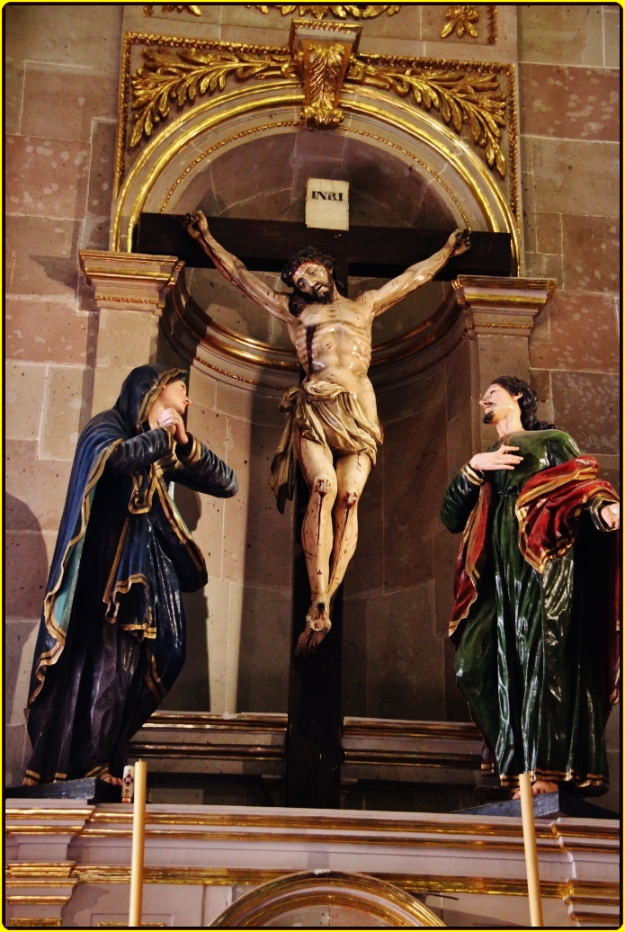 statue of jesus christ on the cross with three women