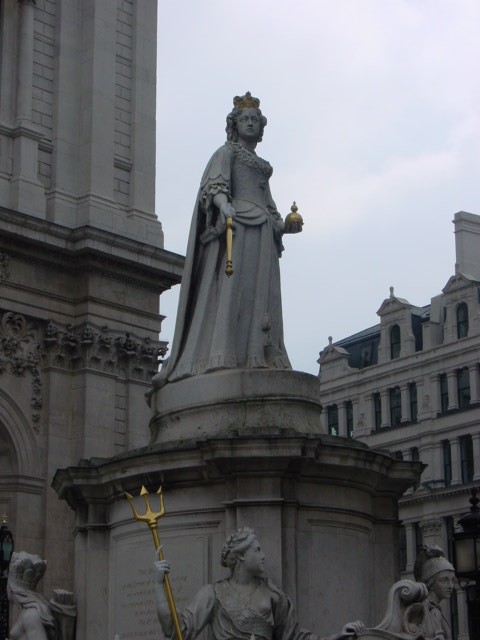 a statue in a city setting on a cloudy day