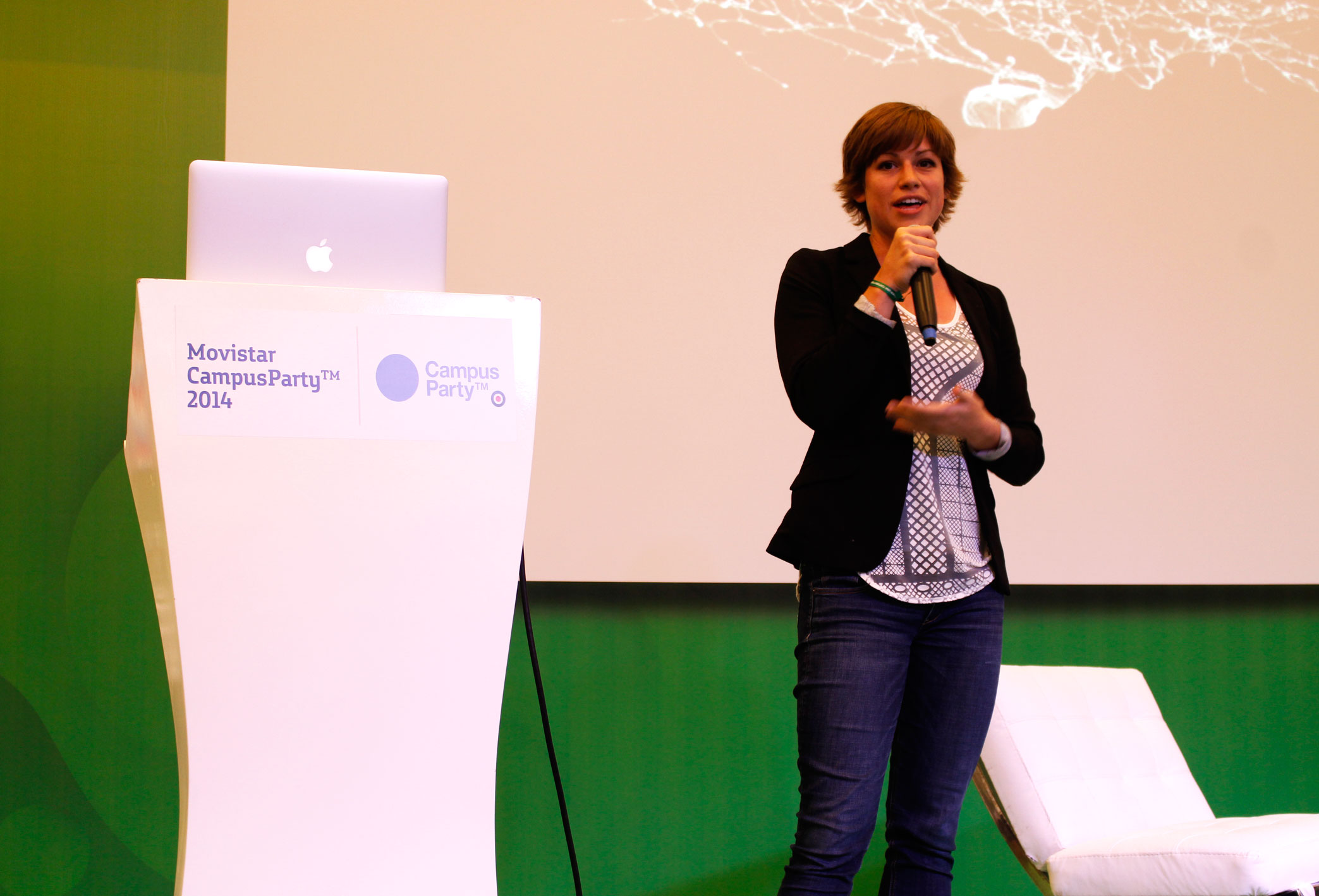 a woman standing in front of a podium and holding a microphone