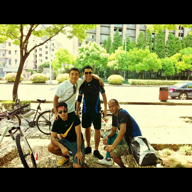 three men standing next to each other near bicycles