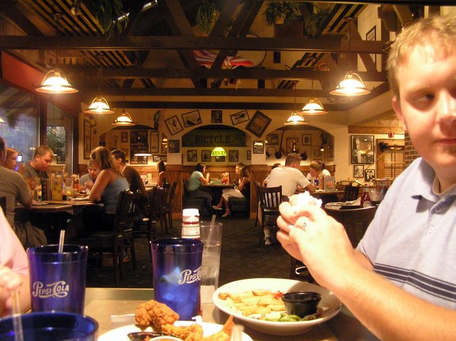 a man eats at a restaurant with several different foods