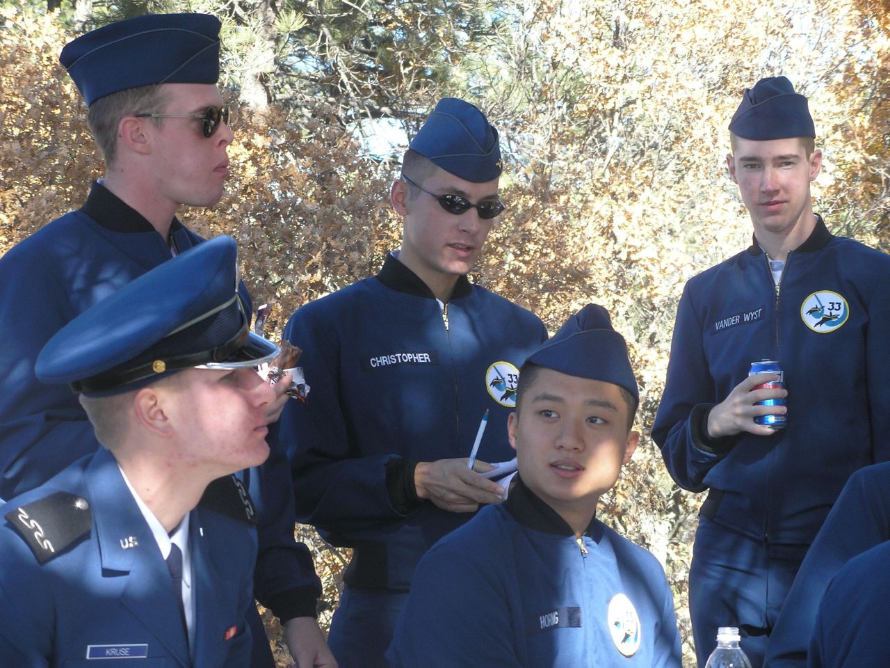 a group of people standing around each other wearing blue uniforms