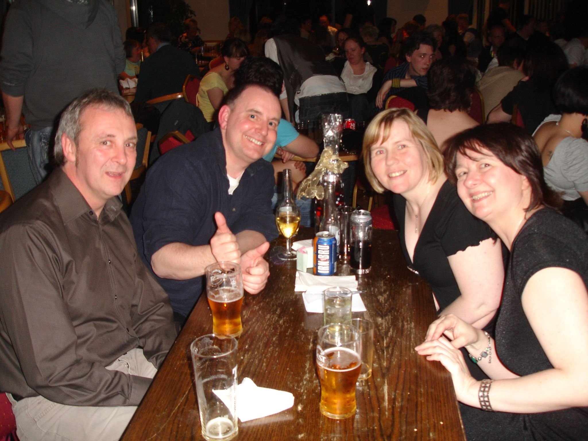 three people sitting at a table with glasses