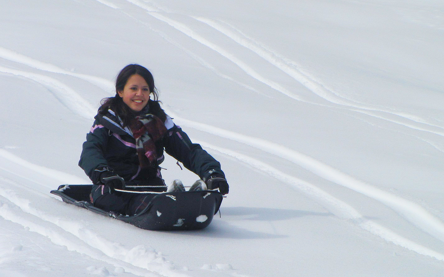 there is a woman sitting on the snowboard in the snow