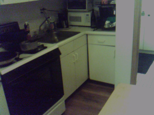 there is a sink, stove, microwave and a refrigerator