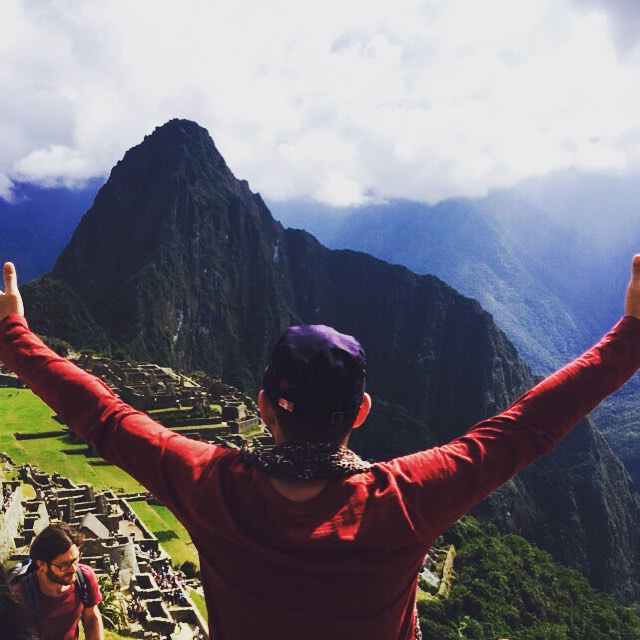 a woman stands on a mountain overlooking a mountainous city