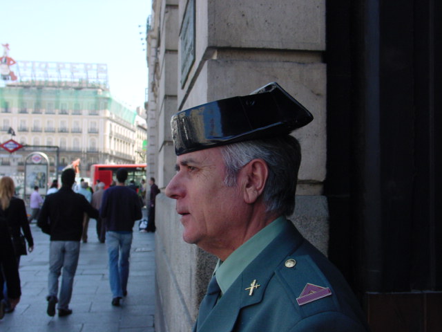 a man wearing an army uniform stands by a building