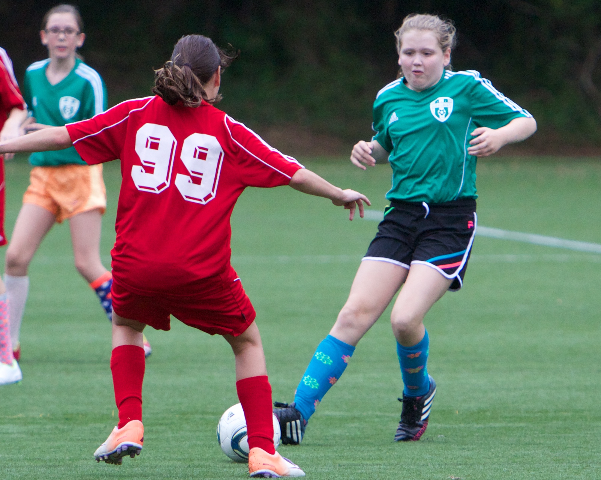 a group of girls in uniforms playing soccer