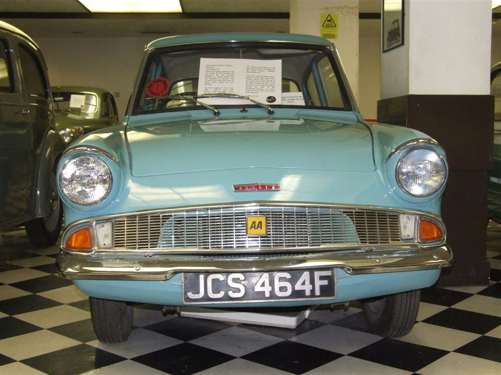 a blue classic car on display in a museum