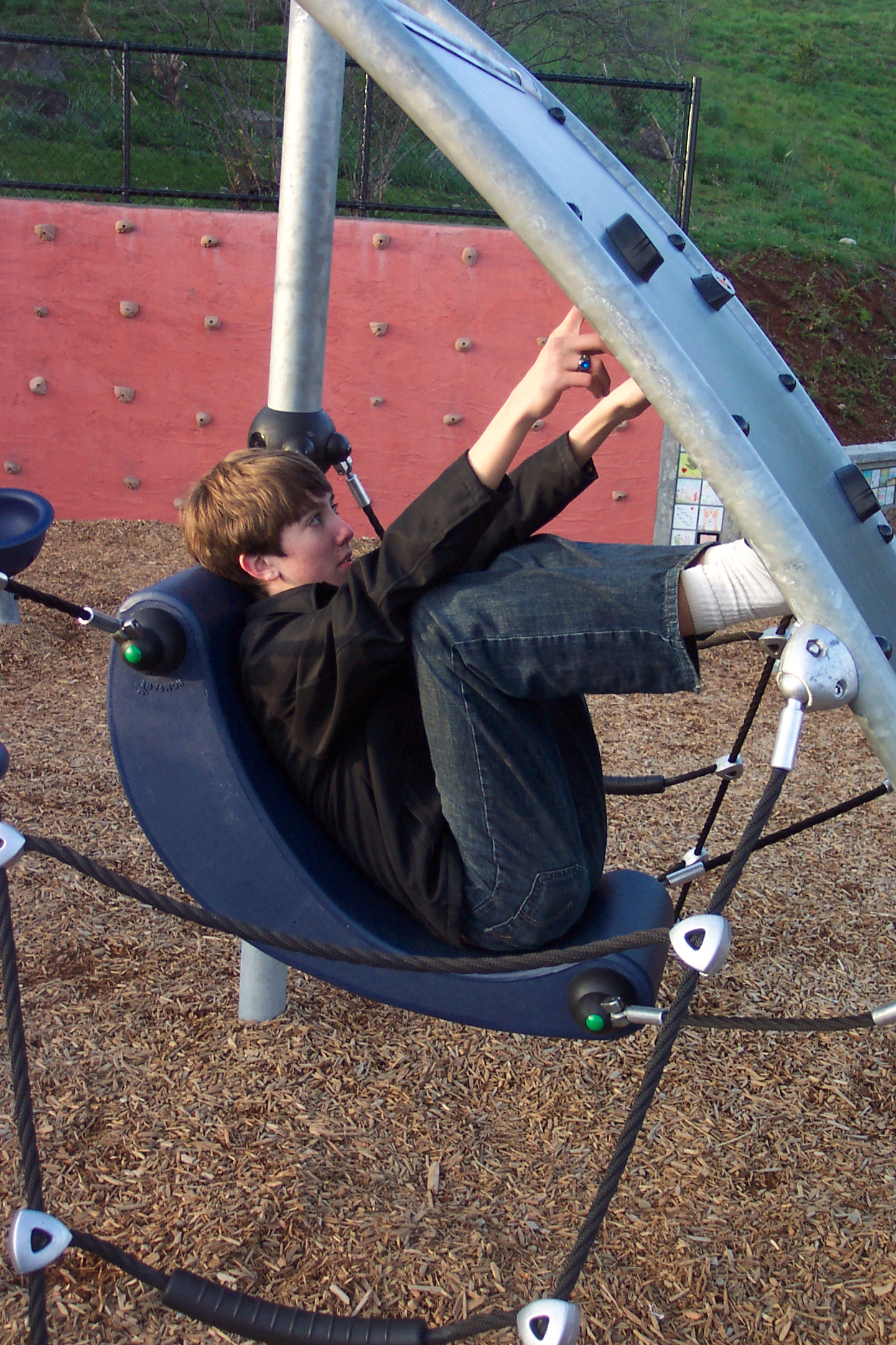 a  is riding on a playground swing