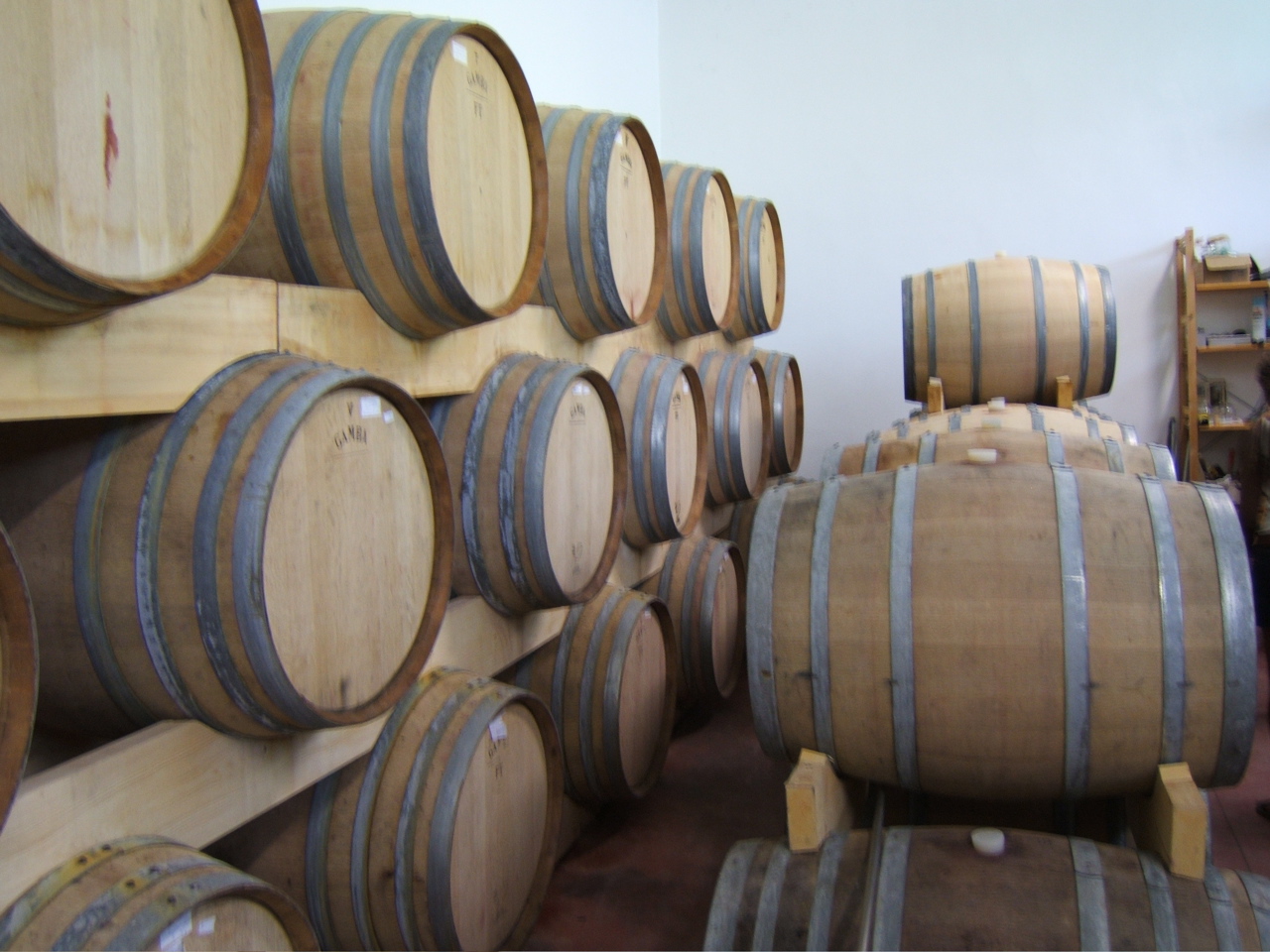 several stacks of wine barrels in the cellar