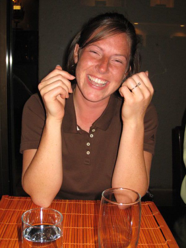 a woman smiling and holding a glass of wine