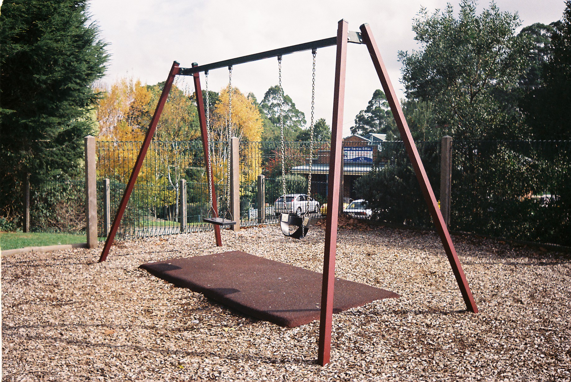 a playground swing frame with a chain at the bottom