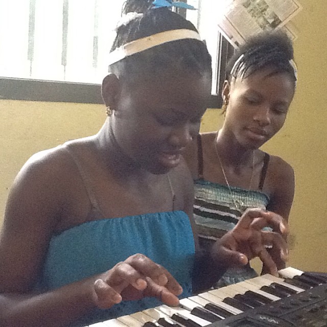 two women look at an electronic keyboard together