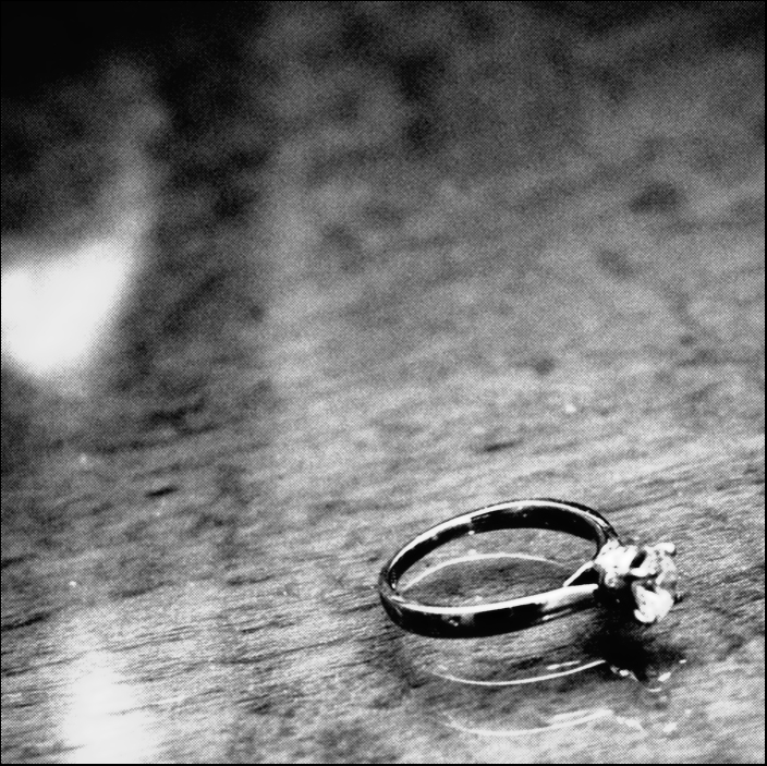 an open ring on a counter top with a flower growing from the middle