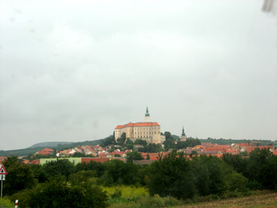 view from across a grassy field to buildings and hills