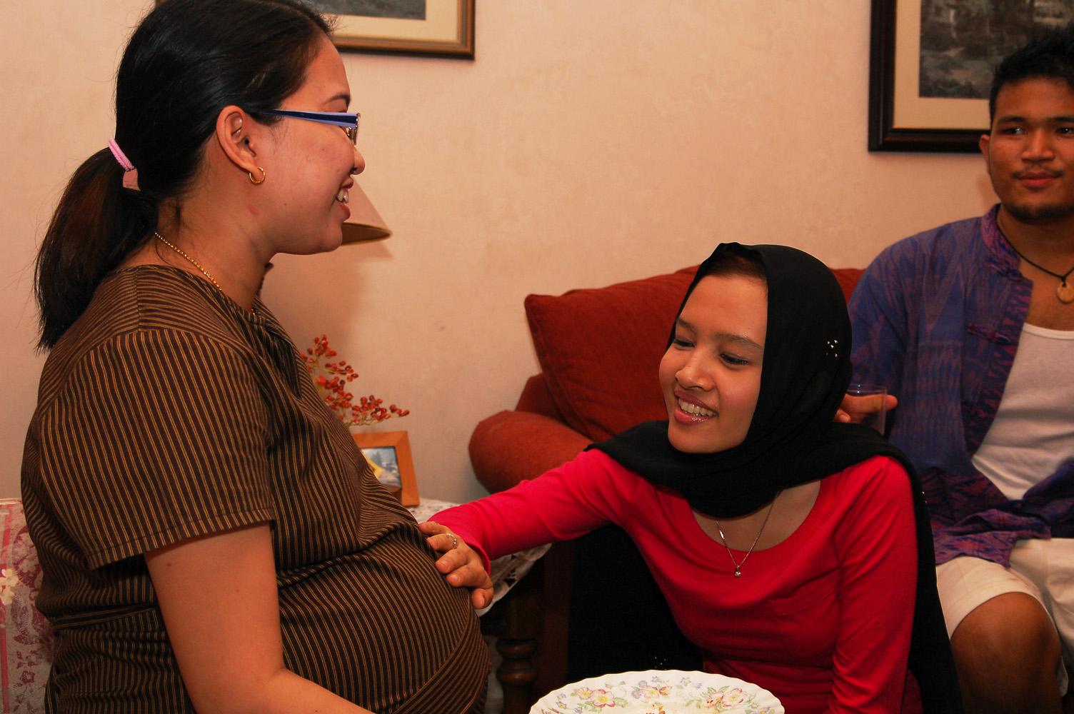 two pregnant women and a man are smiling together