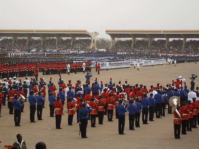 a group of men in blue and red uniforms marching through a crowd