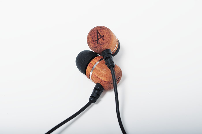 a wooden earbud plugging with an initial on it