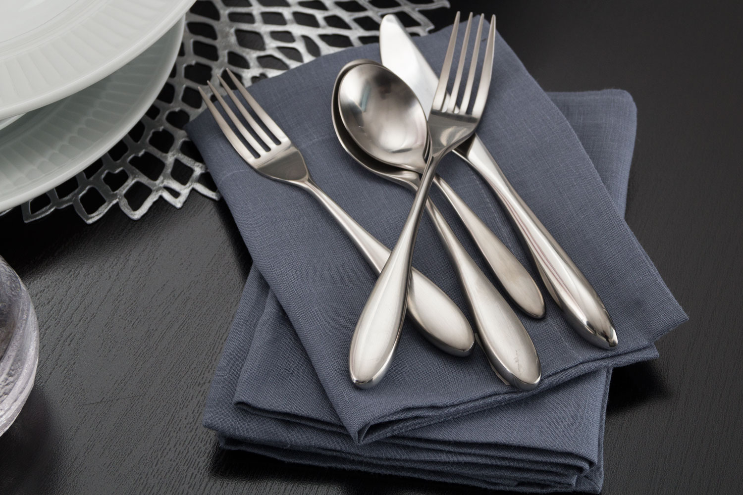 a fork, knife and two spoons on top of napkins