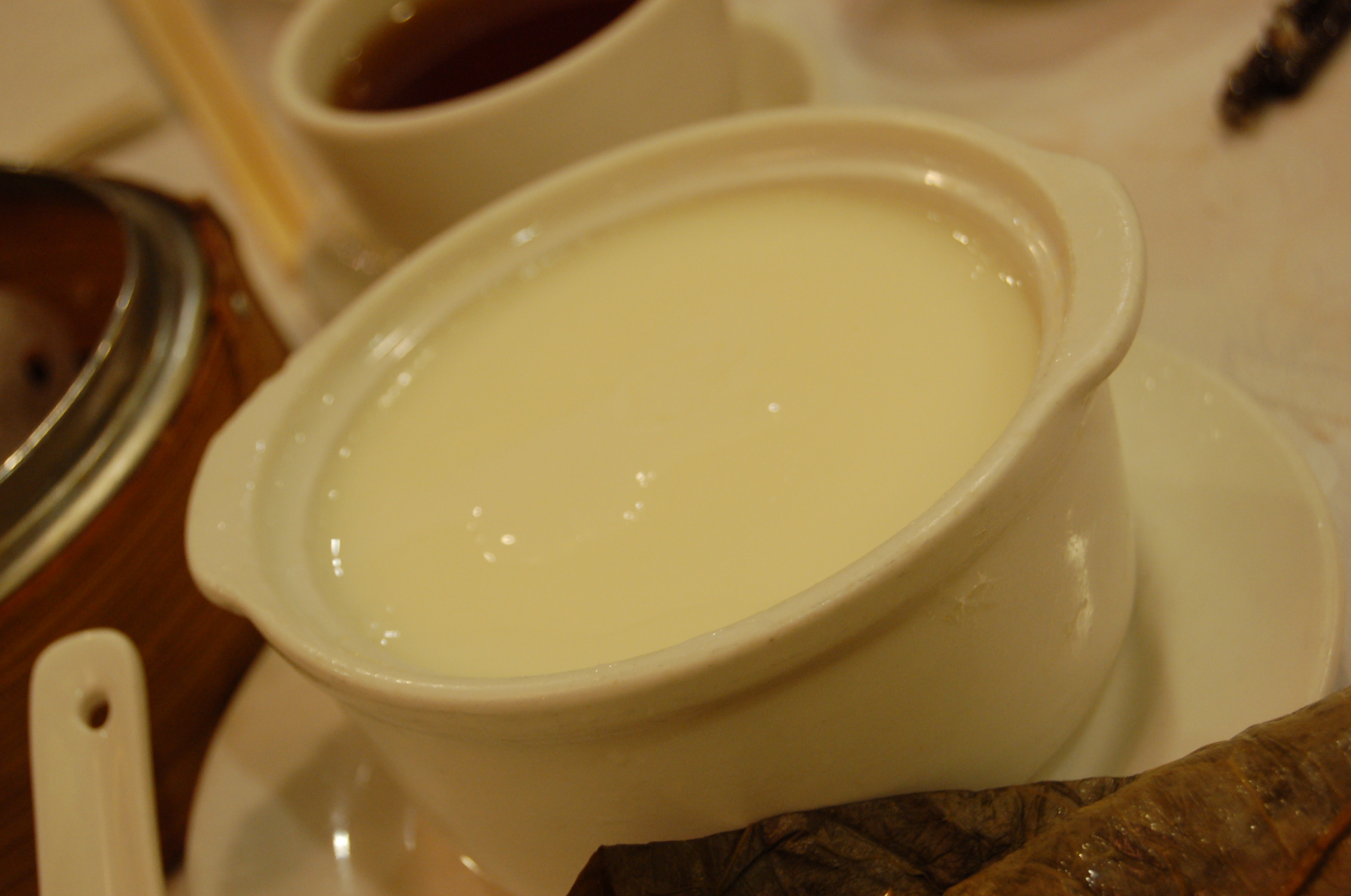 a bowl of cream is placed next to two plates