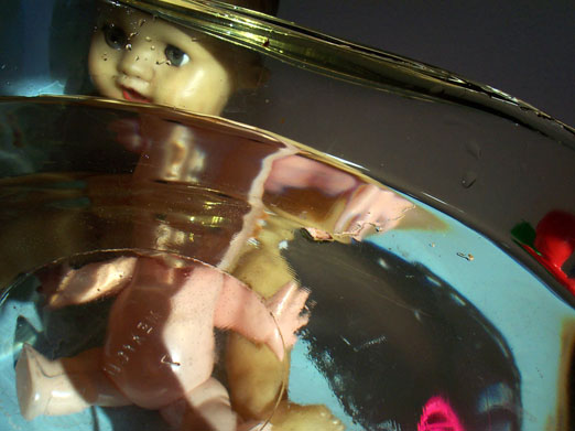 a baby doll in a bowl on top of a table