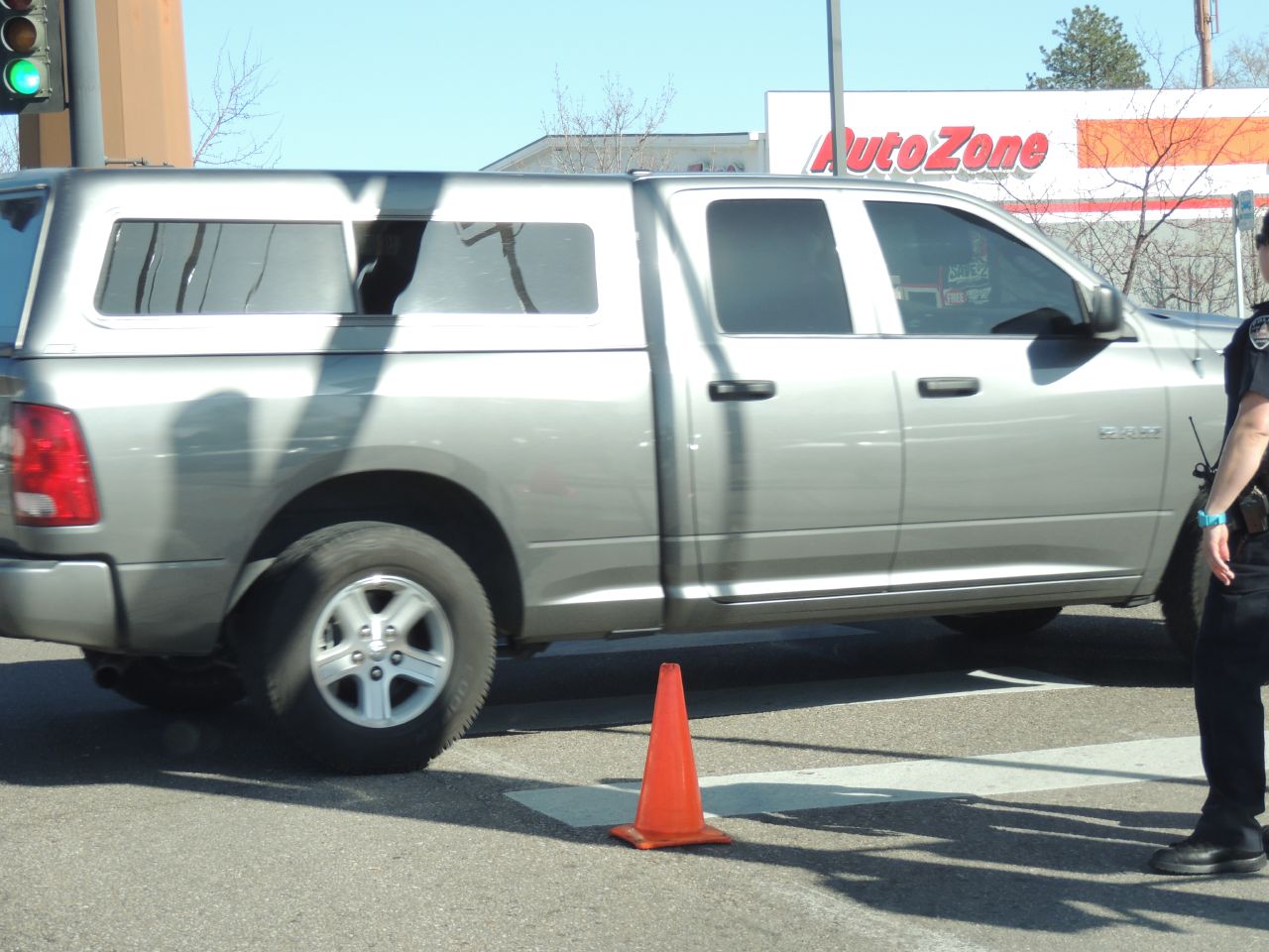 a man standing next to a parked silver dodge ram