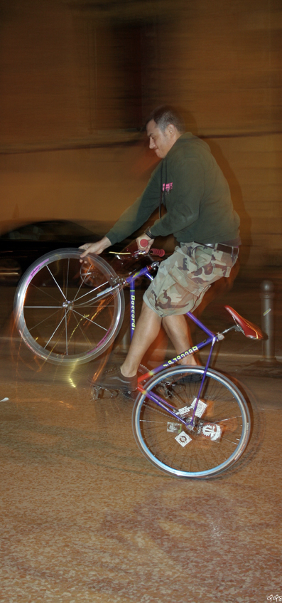 a man riding a blue bike down the street