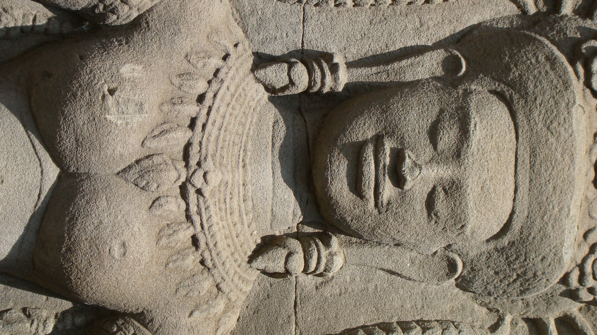 close up s of the head and torso of a carved stone statue