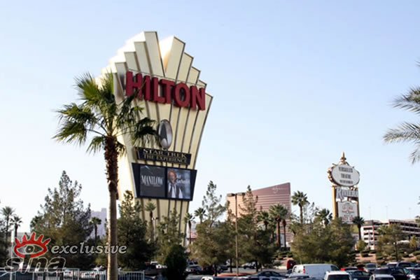 the sign is beside the palm trees at the mall