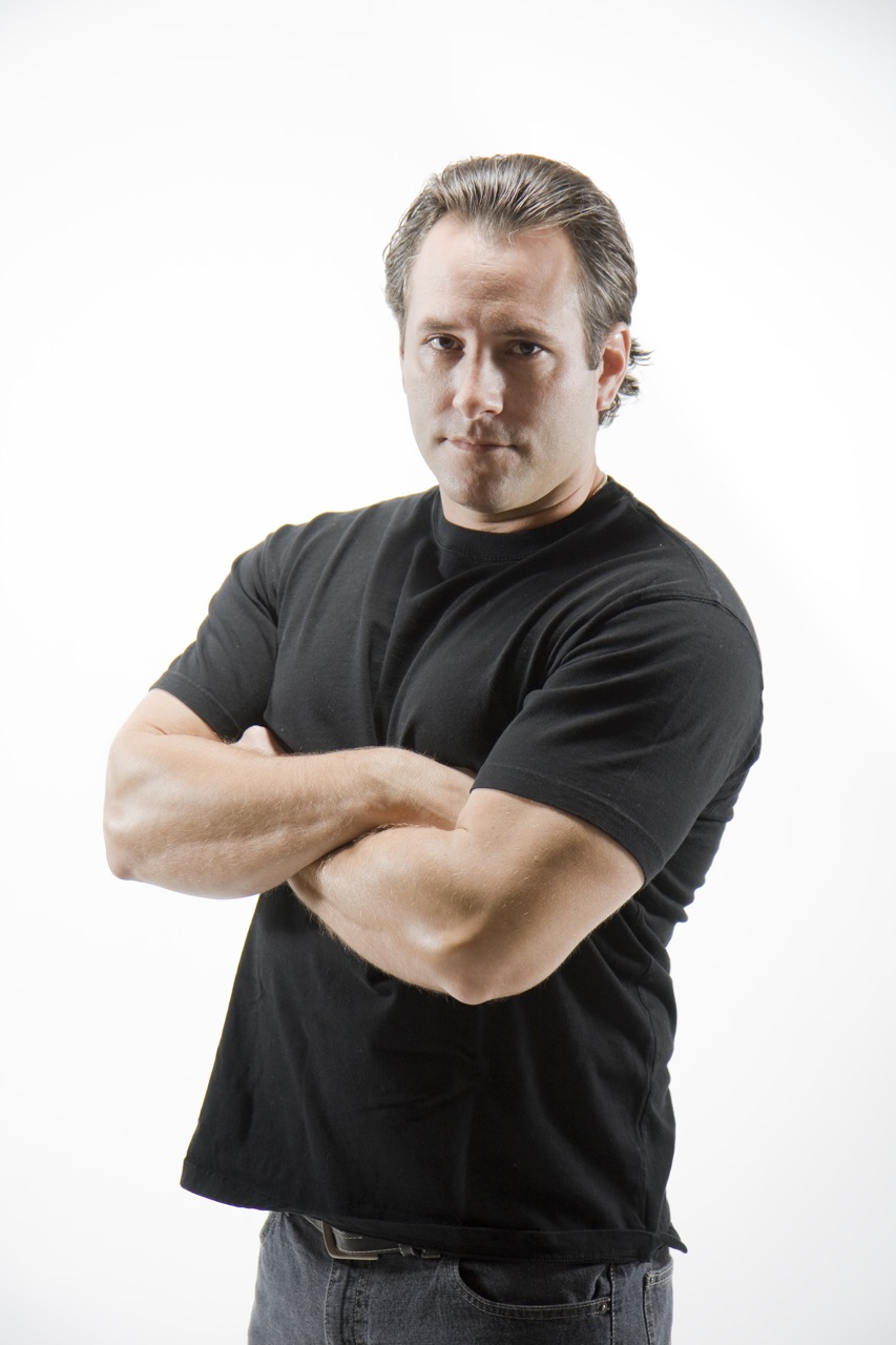 a man is wearing a black shirt and his arms crossed