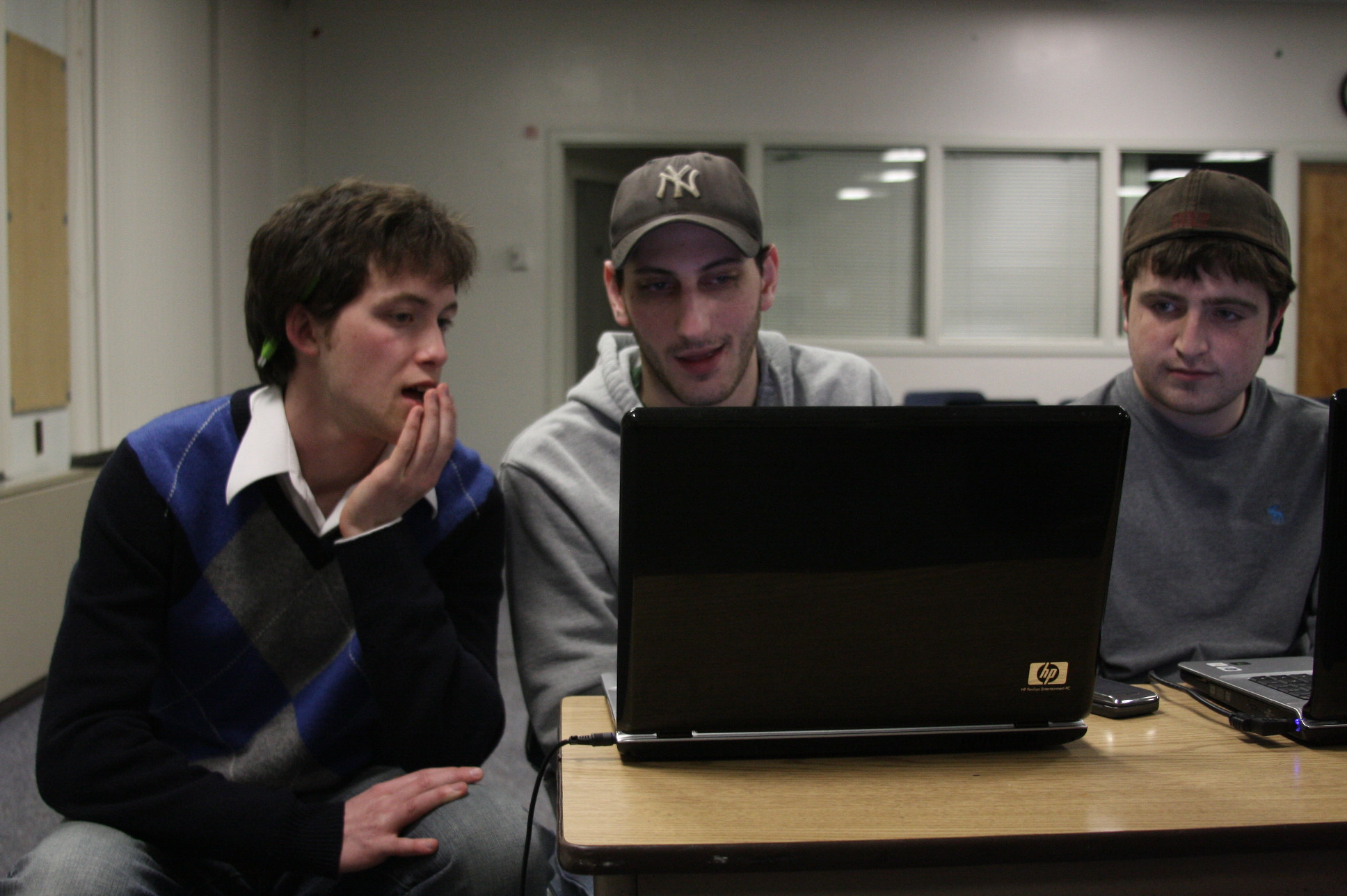 two boys in a room looking at a laptop
