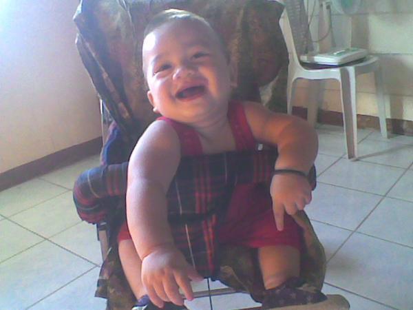 small child on a big chair with his mouth open and a smile
