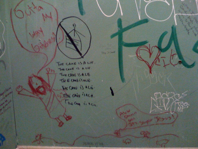 several graffiti drawings on the bathroom wall