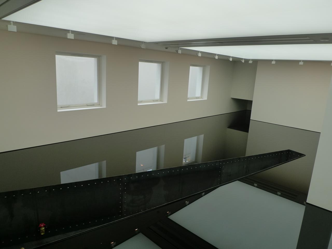 a room with windows and black floor, painted white