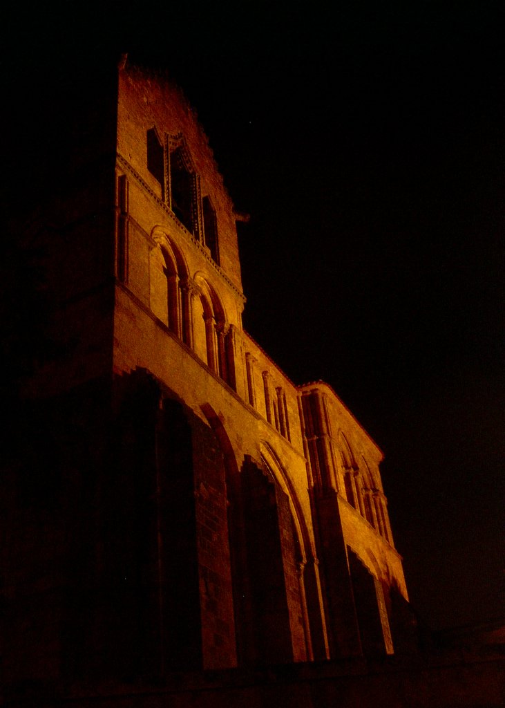 the tower of an old building lit up at night