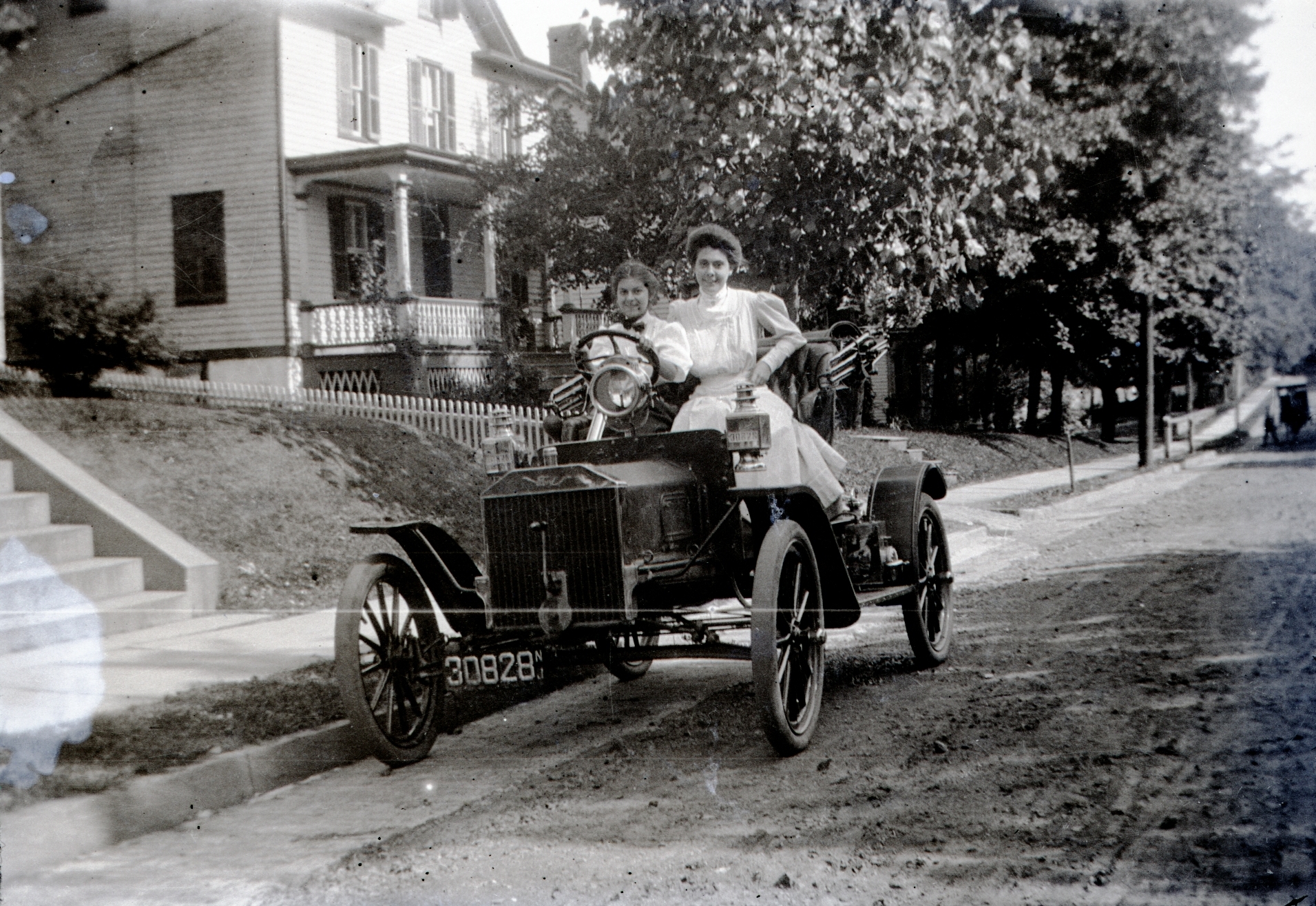 a woman is driving an old fashioned car