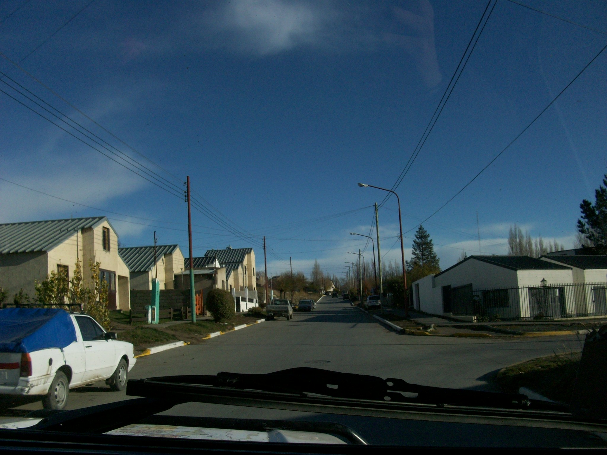 a car driving down a street past residential houses