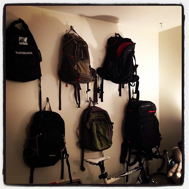 a number of bags and bikes hanging from the wall