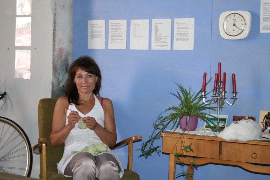 a girl sitting in a chair knitting