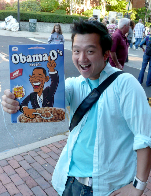 a man in a blue shirt and tie holding up a obama sign