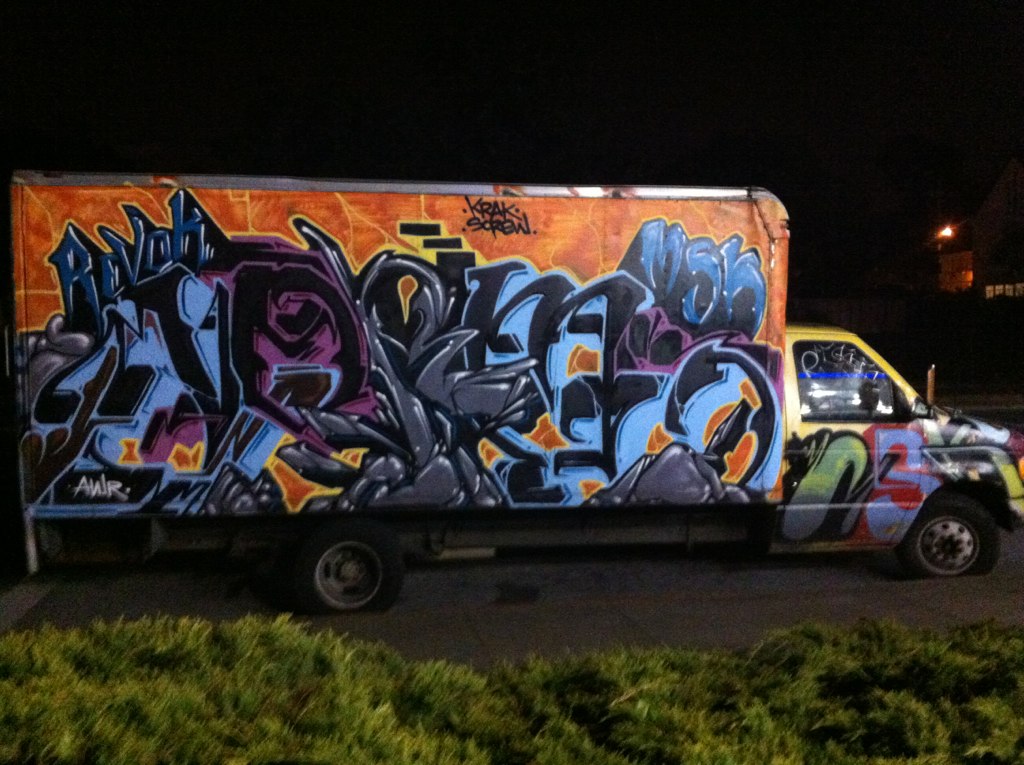 a graffiti covered box truck parked in a lot