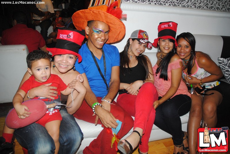 a couple sitting on a bench with young children wearing hats