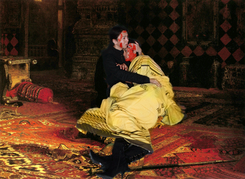 a man in a red dress sits on the floor next to an image of a vampire