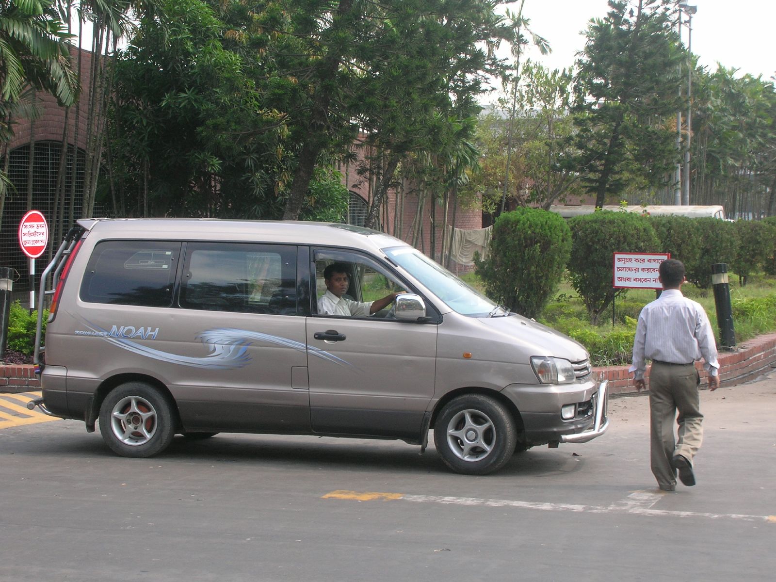 a van and man in street area near bushes